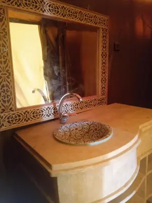 a bathroom counter with a sink and a mirror at Luxury Camp Sahara in Merzouga