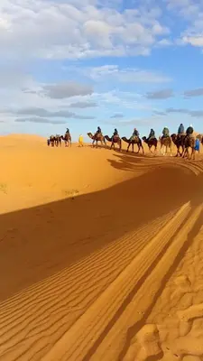 a group of people riding horses in the desert at Luxury Camp Sahara in Merzouga