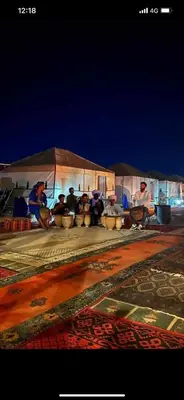 a group of people sitting under a tent at luxury camp desert ideal in Merzouga