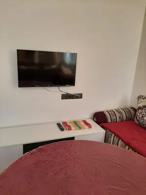 a bedroom with a bed and a flat screen tv on the wall at Dar Igri in Ourika