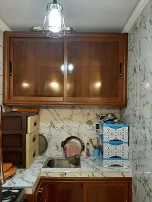 a kitchen counter with a sink and wooden cabinets at Dar Igri in Ourika