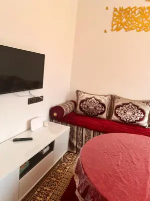 a living room with a red couch and a flat screen tv at Dar Igri in Ourika