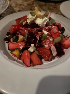 a white plate with a fruit salad on a table at Touareg spirit luxury Camp in Merzouga