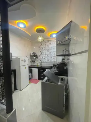 a kitchen with a stove and a white refrigerator at Dans un bâtiment in Meknès
