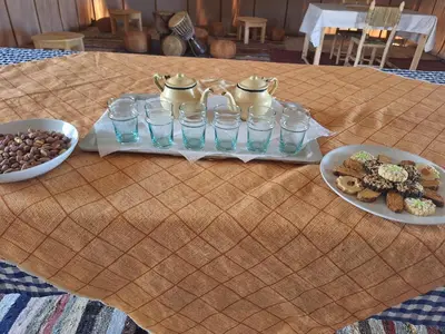 a table topped with plates of food and glasses of water at Infinity Camp Morocco in Mfis