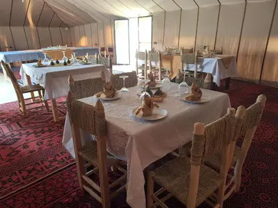 a dining room with tables and chairs with hats on them at Infinity Camp Morocco in Mfis