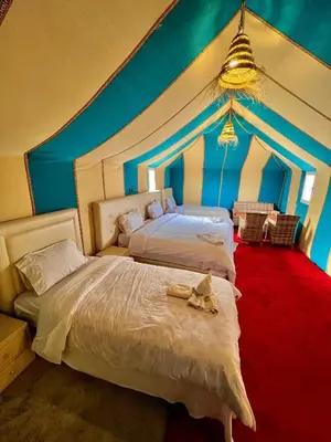 two beds in a room with blue walls at Incredible luxury Camp in Merzouga