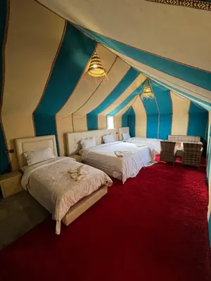 two beds in a room with a tent at Incredible luxury Camp in Merzouga