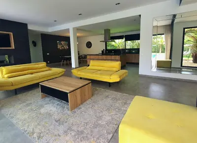 a living room with yellow couches and a table at Not overlooked villa with heated pool 4 suites in Oulad Akkou