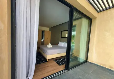 a bedroom with a bed and a large window at Not overlooked villa with heated pool 4 suites in Oulad Akkou