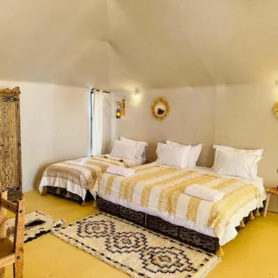 a bedroom with two beds in a room at Sand Dunes Luxury Camp in Merzouga