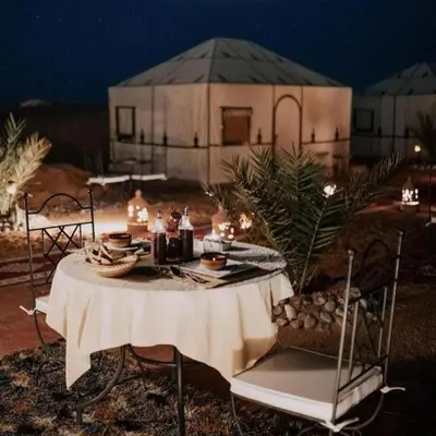 a table with food on it in front of a building at Sand Dunes Luxury Camp in Merzouga