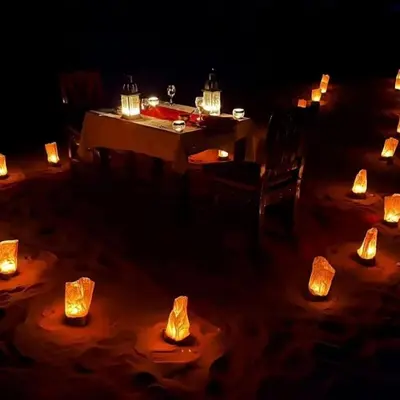 a table with candles on it in the dark at Sand Dunes Luxury Camp in Merzouga