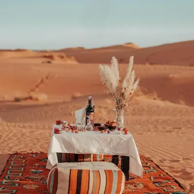 a table in the middle of the desert at Sand Dunes Luxury Camp in Merzouga