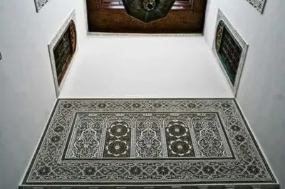 a tile floor with a clock on a wall at Dar lmallouki 2 in Fès