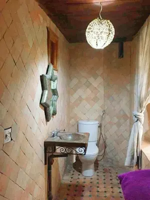 a bathroom with a toilet and a sink and a chandelier at Dar lmallouki 2 in Fès