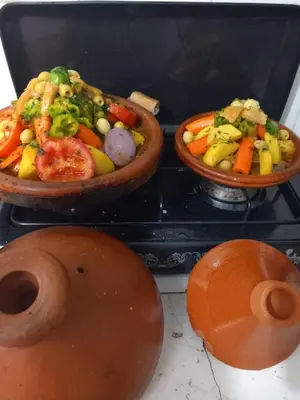 three bowls of vegetables and other food on a stove at Dar lmallouki 2 in Fès