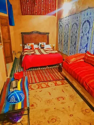 a bedroom with two twin beds and a rug at Dar lmallouki 2 in Fès