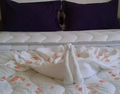 a bed with white blankets and flowers on it at Belle vue Belle situation in Ifrane