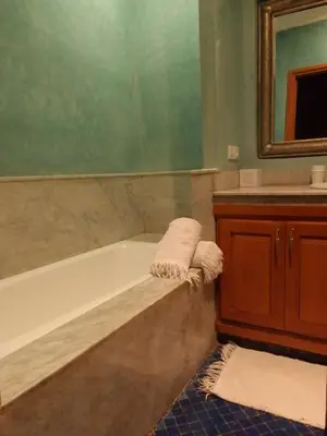 a bathroom with a tub and a sink and a mirror at Maria in Najem