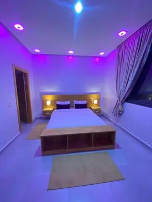 a bedroom with a large bed with purple lighting at Villa wazoo in Marrakech