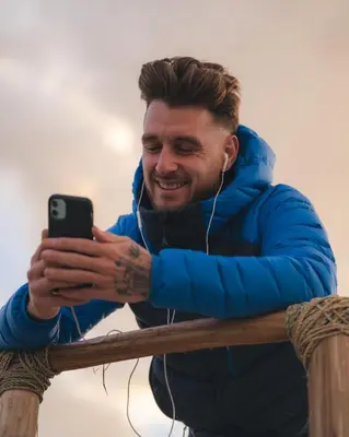 a man is smiling while looking at his cell phone at Pikala Home in Ourika