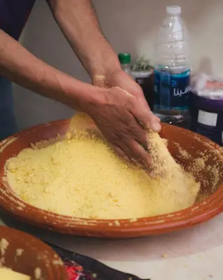 a personeading a bowl of food on a table at Pikala Home in Ourika