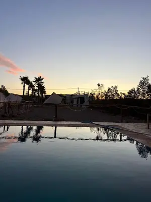 a pool of water with a sunset in the background at Pikala Home in Ourika