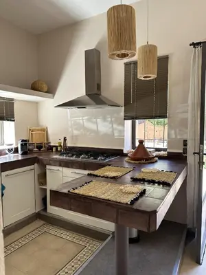 a kitchen with a wooden counter top in a kitchen at Villa Hania 4 chambres avec piscine in Heddad