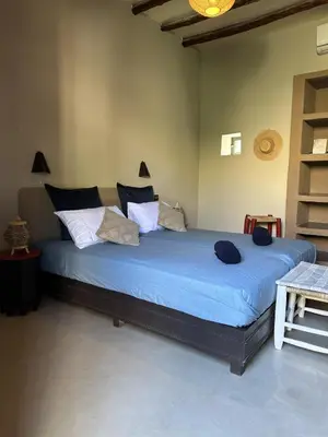 a large bed with blue sheets in a room at Villa Hania 4 chambres avec piscine in Heddad