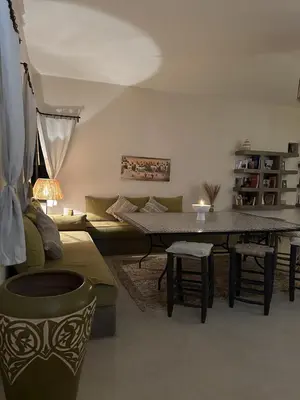 a living room with a table and a couch at Villa Hania 4 chambres avec piscine in Heddad