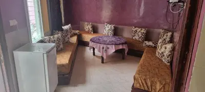 a room with two beds and a table in it at منزل باهية in Moulay Yacoub