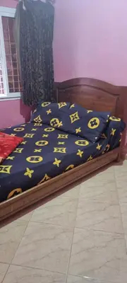 a bed with a blue comforter with yellow stars on it at منزل باهية in Moulay Yacoub