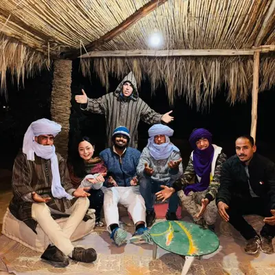 a group of people posing for a picture in a hut at Merzouga Marvelous Camp in Merzouga