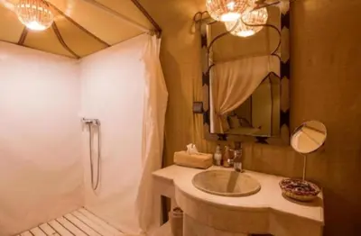 a bathroom with a tub and a sink and a shower at Merzouga Marvelous Camp in Merzouga