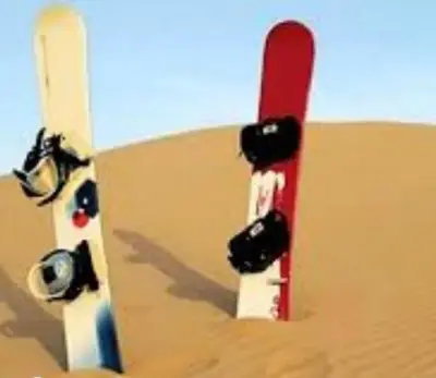 a snowboard stuck in the sand in the desert at Merzouga Marvelous Camp in Merzouga