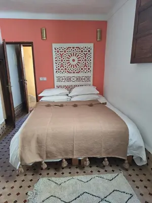 a bedroom with a large bed with red walls at Appartement privé Medina in Fès