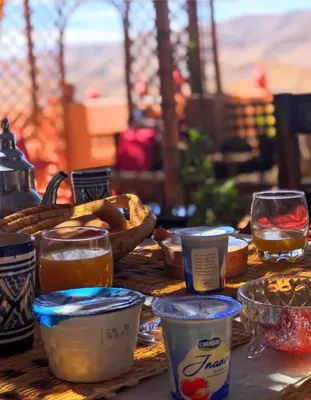 a table with some food and drinks on it at Riad La Perle Tamnougalte in Agdz
