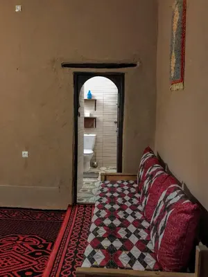 a room with a bed in a room with a bathroom at Riad La Perle Tamnougalte in Agdz