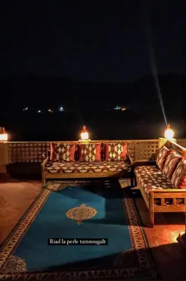a couch sitting on a patio at night at Riad La Perle Tamnougalte in Agdz