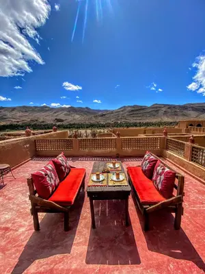 a patio with a table and two chairs and a table at Riad La Perle Tamnougalte in Agdz