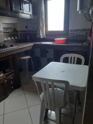 a kitchen with a table and two chairs and a table at Appartement Fascinant à Meknès in Meknès