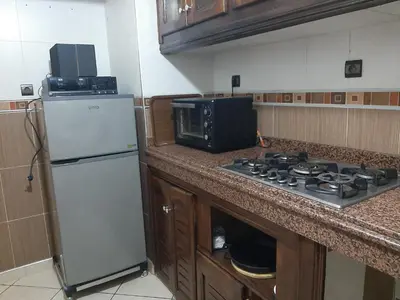 a kitchen with a stove and a white refrigerator at Appartement Fascinant à Meknès in Meknès