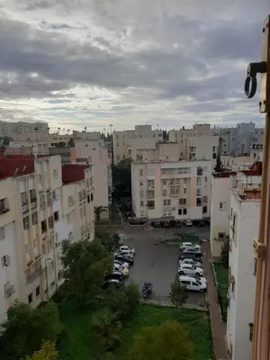 a city with cars parked in a parking lot at Appartement Fascinant à Meknès in Meknès