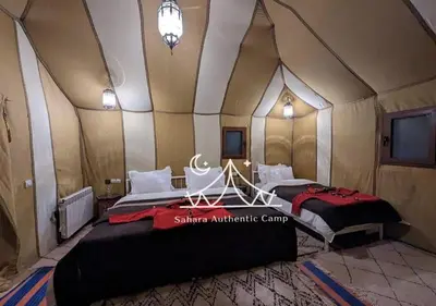 a room with two beds in a tent at Sahara Authentic Camp in Merzouga