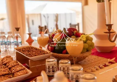 a table with a bunch of different types of food at Sahara Authentic Camp in Merzouga