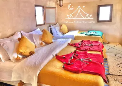 a group of three beds in a room at Sahara Authentic Camp in Merzouga
