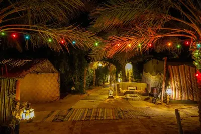 a living room with christmas lights on a palm tree at Sahara Garden Luxury Camp in Merzouga