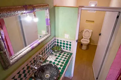 a bathroom with a sink and a mirror and a toilet at Sahara Garden Luxury Camp in Merzouga