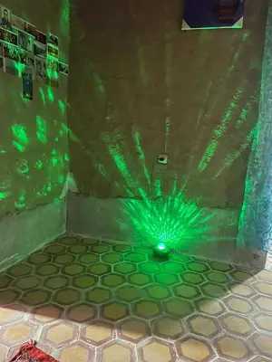 a green room with a shower with a glass floor at Guest House For Rent Merzane in Merzane